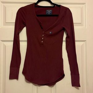 Maroon long sleeve ribbed shirt with buttons.